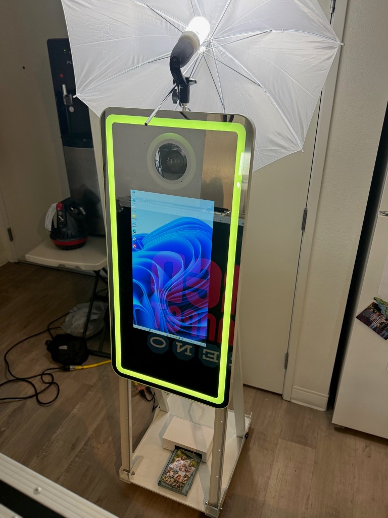 Shows a Magic Mirror Photo Kiosk with lighting and printer